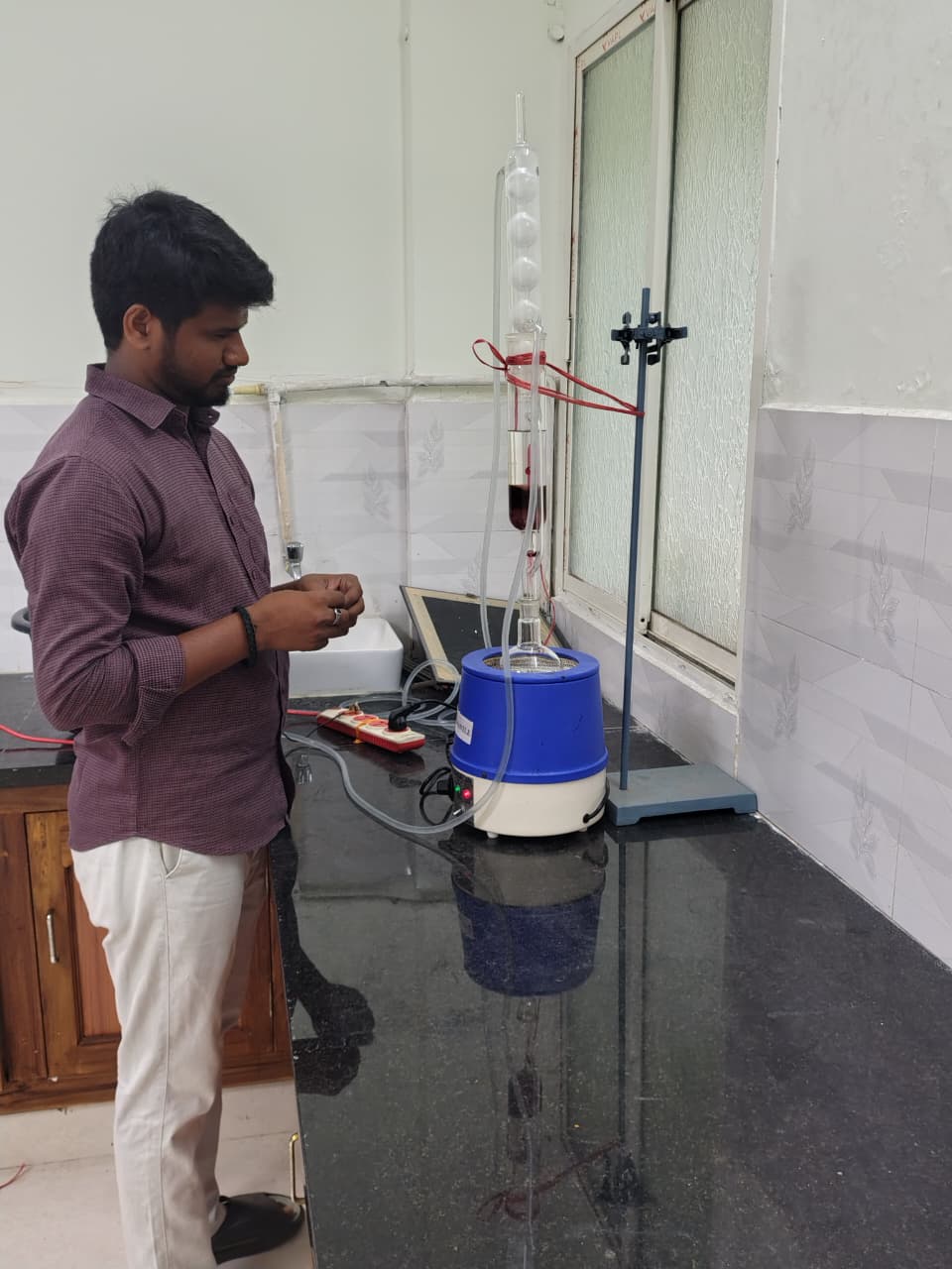 R&D lab analyst monitoring a glassware extraction setup on a heating mantle at the Strive Aqua R&D centre